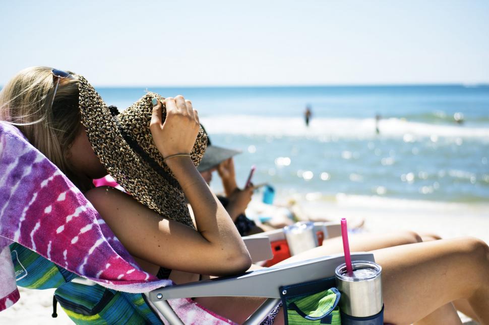 Free Image of Woman Sitting in Chair on Beach 