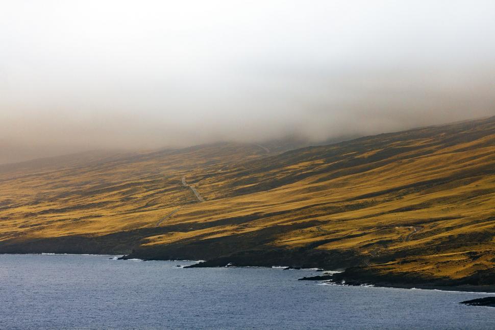 Free Image of Plane Flying Over Water on a Foggy Day 