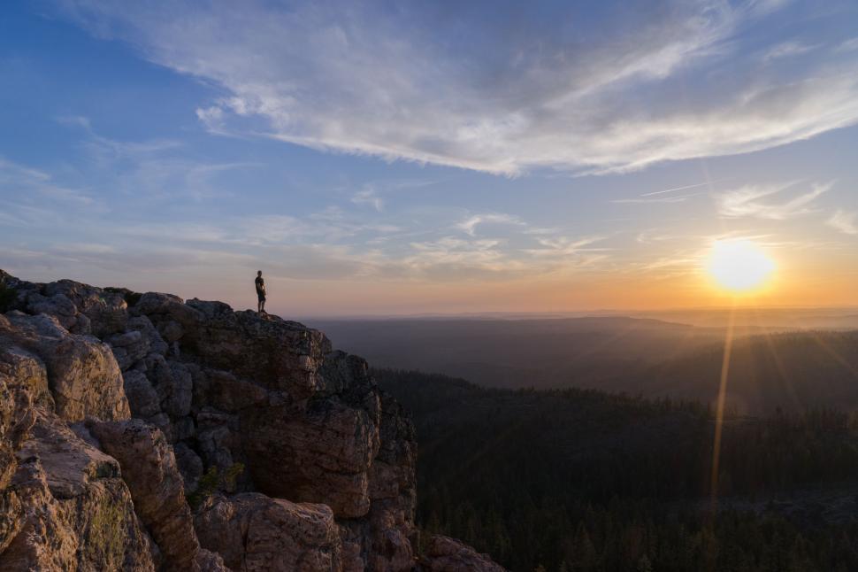 Free Image of Person Standing on Top of Mountain at Sunset 