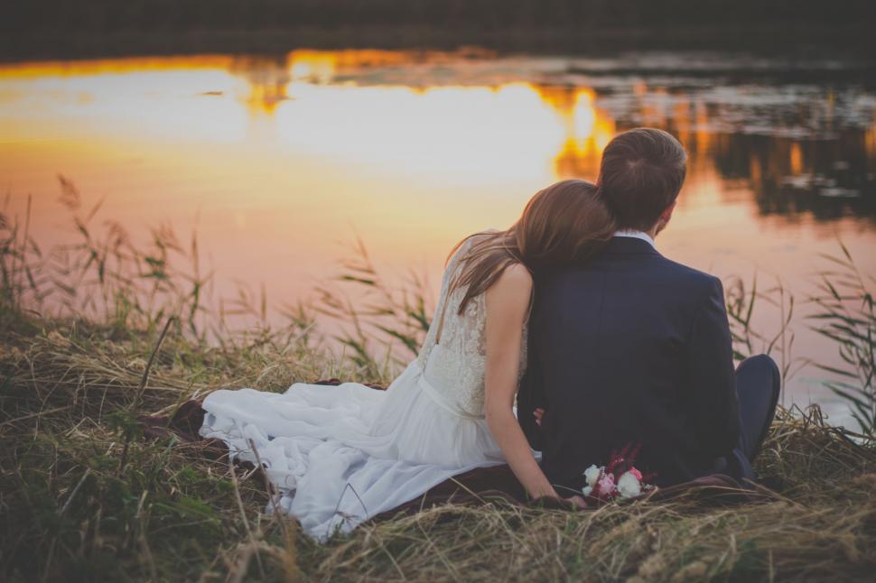Free Image of Man and Woman Sitting by Water 