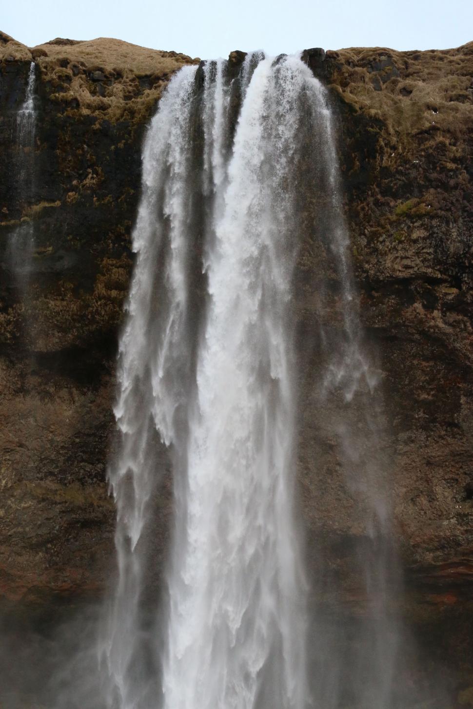 Free Image of Man Standing in Front of Waterfall 