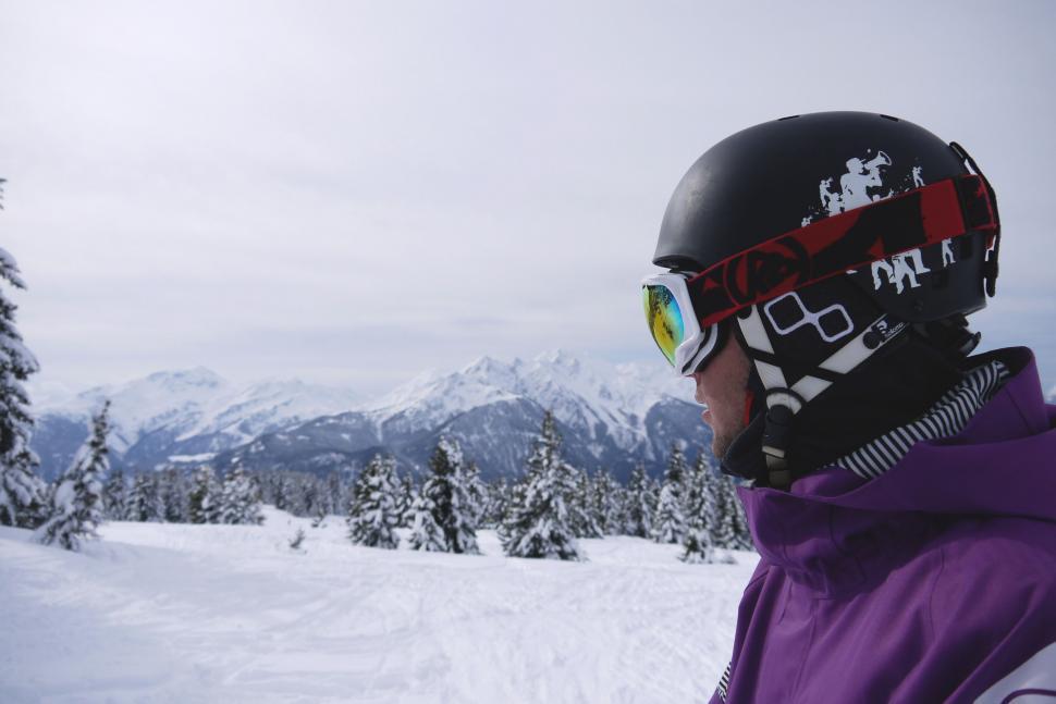 Free Image of Person in a Purple Jacket Snowboarding 