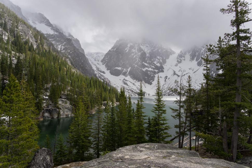 Free Image of Rocky Outcropping With Trees and Mountain in Background 