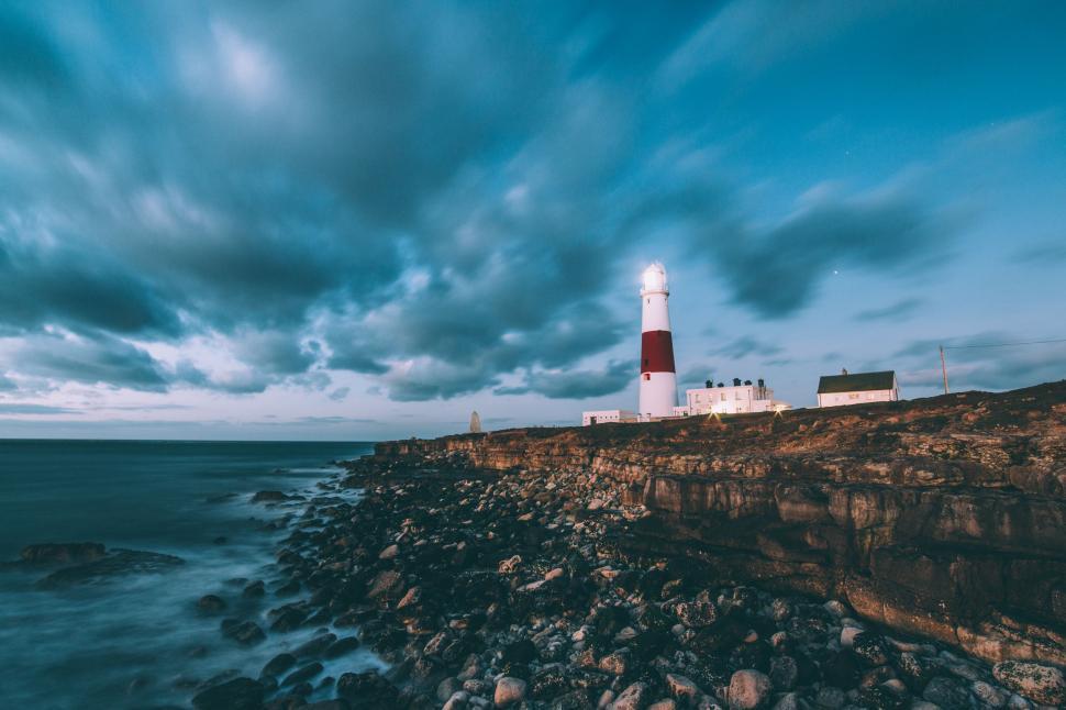 Free Image of Lighthouse on Cliff Overlooking Ocean 