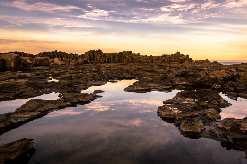 Free Image of Rocky Water Body Under Cloudy Sky 