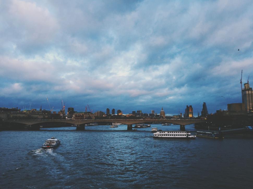 Free Image of Boat Traveling Down River Under Cloudy Sky 