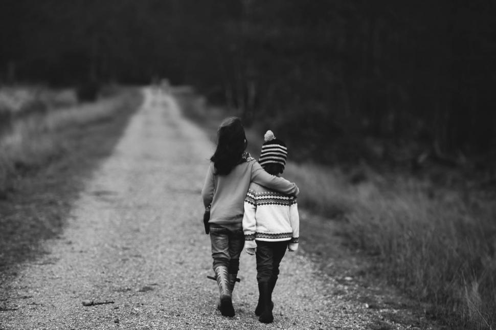 Free Image of Mother and Child Walking Down a Dirt Road 