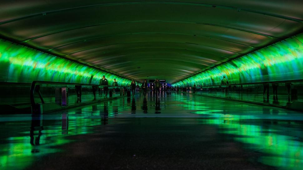Free Image of People Walking Through a Tunnel With Green Lights 