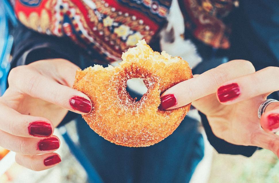 Free Image of Woman Holding a Donut in Her Hands 