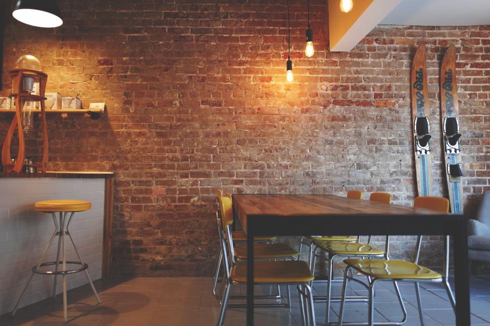 Free Image of Room With Table, Chairs, and Surfboard on Wall 