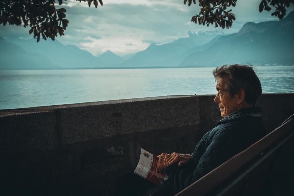 Free Image of Man Sitting on Bench by Water 