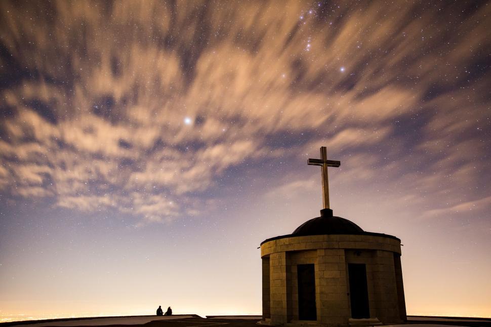 Free Image of Cross Atop a Building Under Cloudy Sky 