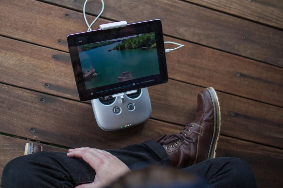 Free Image of Person Sitting on Wooden Floor With Video Game Controller 