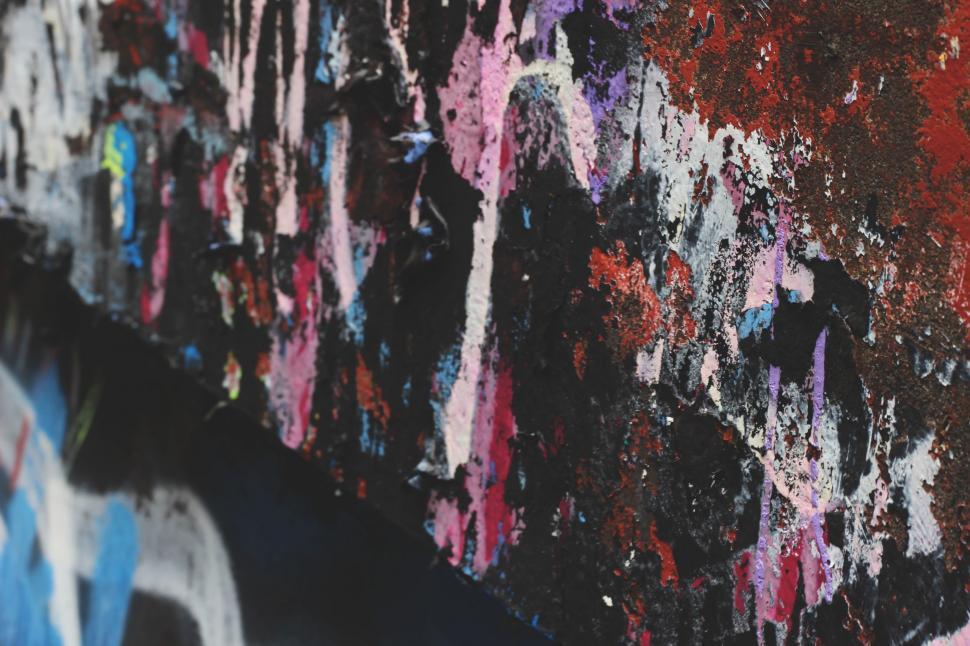Free Image of A Wall Covered in Various Colored Paint 