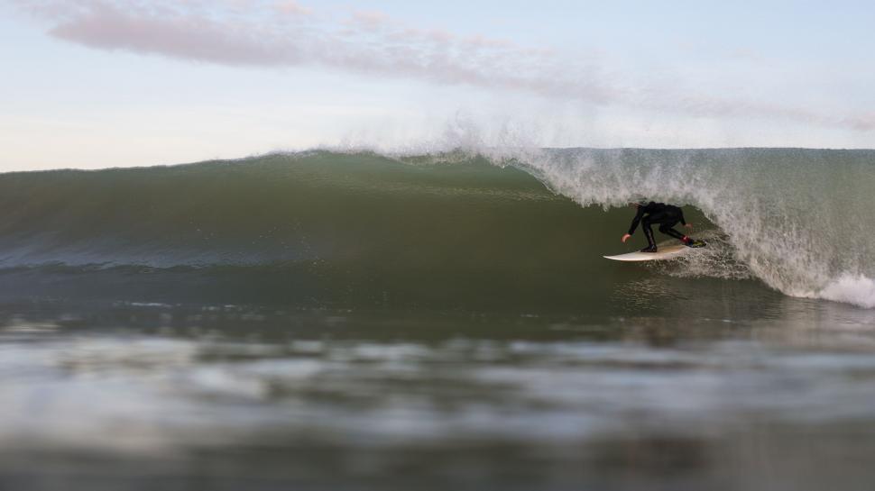 Free Image of Man Riding a Wave on a Surfboard 