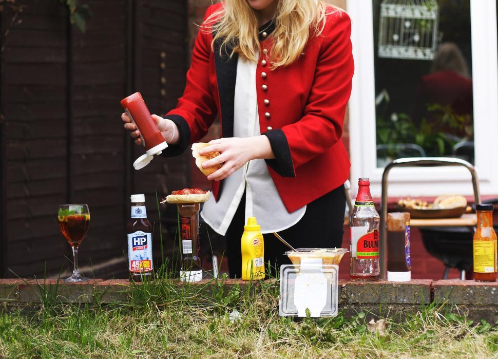 Free Image of Woman in Red Jacket Making Sandwich 