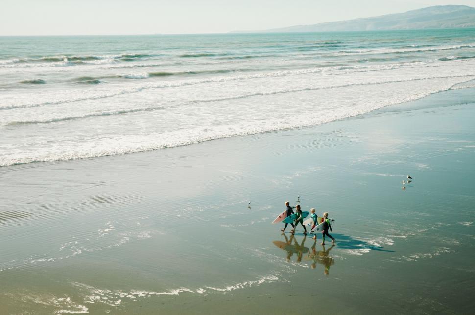 Free Image of Group of People Riding Horses on Top of a Beach 