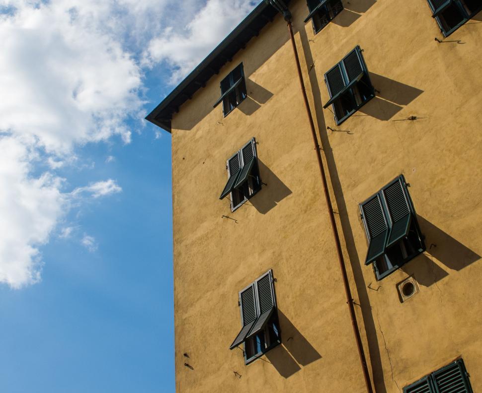 Free Image of Yellow Building With Black Shutters Against Blue Sky 