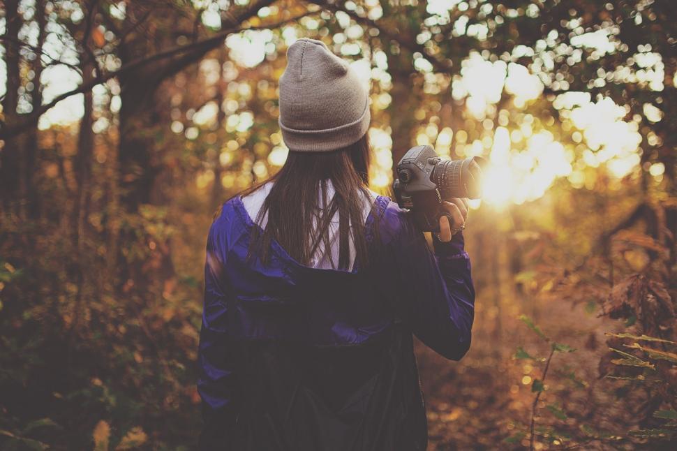 Free Image of Woman Walking Through Forest Holding Bird 