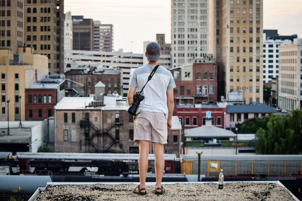 Free Image of Man Standing on Roof With Camera 