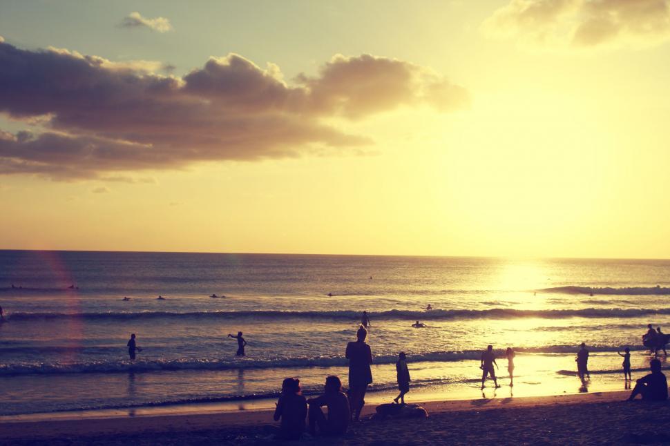 Free Image of Group of People Standing on Top of Beach by the Ocean 