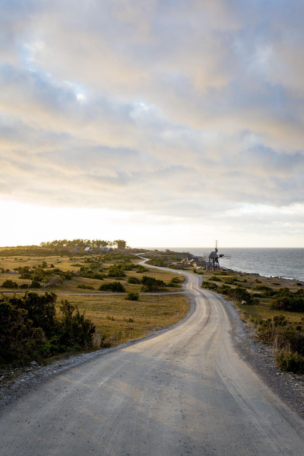 Free Image of Dirt Road Leading to Distant Windmill 