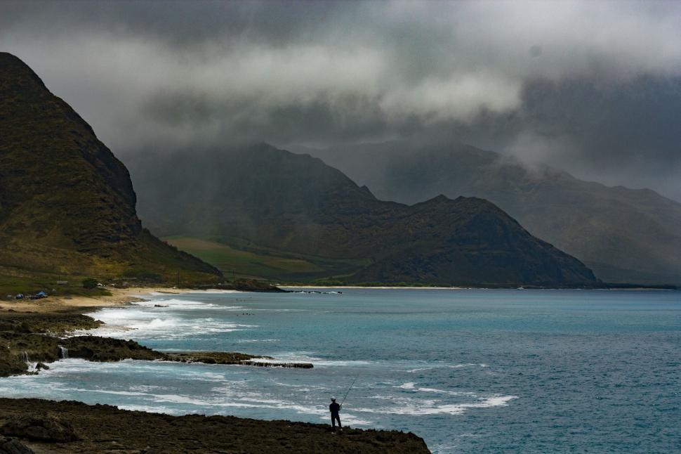 Free Image of Man Standing on Shore of Large Body of Water 