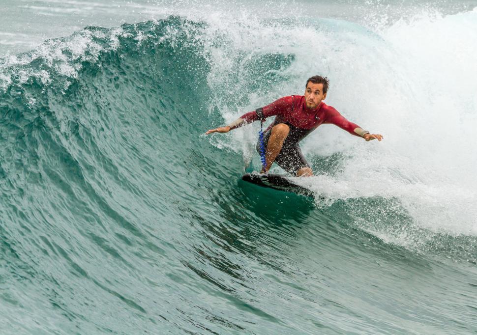 Free Image of Man Riding Wave on Surfboard 
