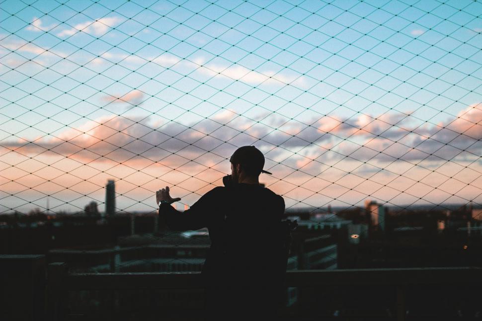 Free Image of Man Standing in Front of Wire Fence 
