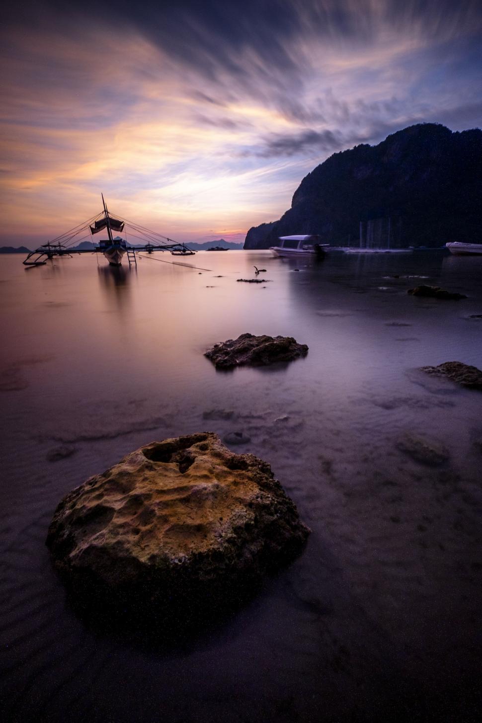 Free Image of Boat Resting on Beach Under Cloudy Sky 