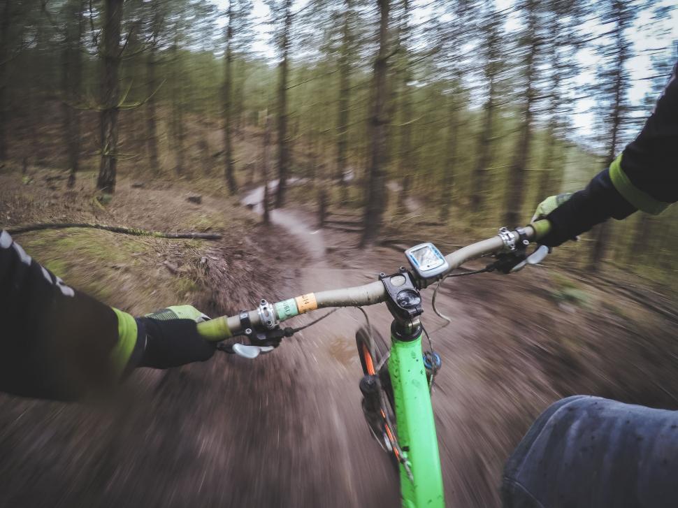 Free Image of Person Riding a Bike Down a Dirt Road 