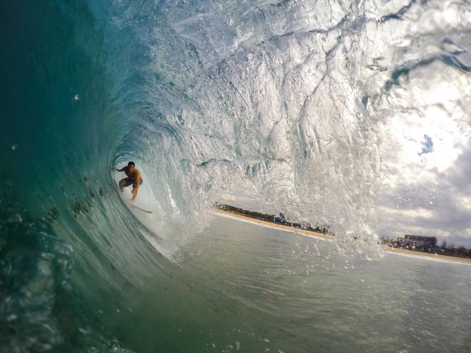 Free Image of Man Riding a Wave on Top of a Surfboard 