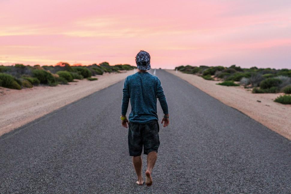 Free Image of Man Walking Down Middle of Road 