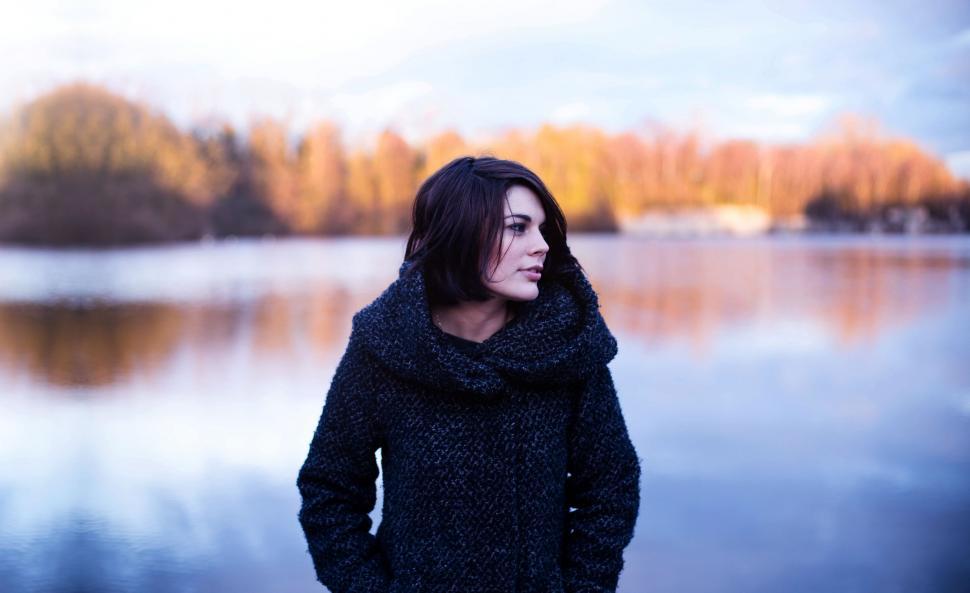 Free Image of Woman Standing in Front of Body of Water 