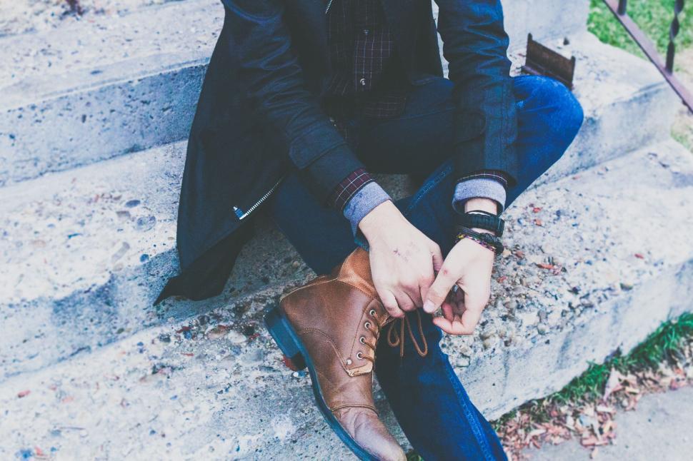 Free Image of Man Sitting on Steps Tying Shoes 