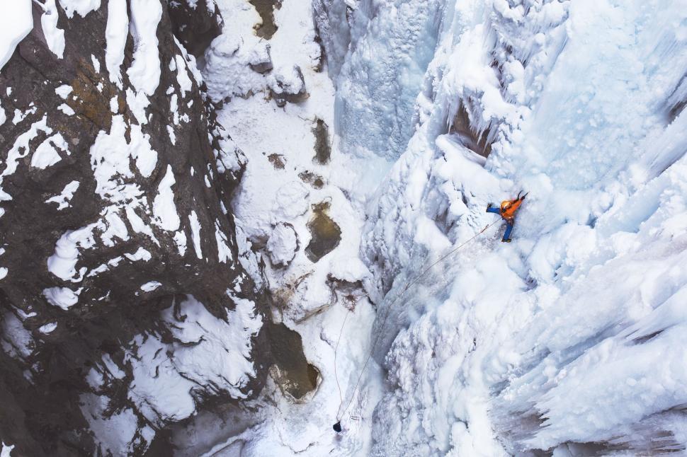 Free Image of Man Climbing Up Snow-Covered Mountain 