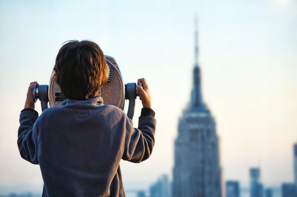 Free Image of Person Holding Skateboard in Front of City Skyline 