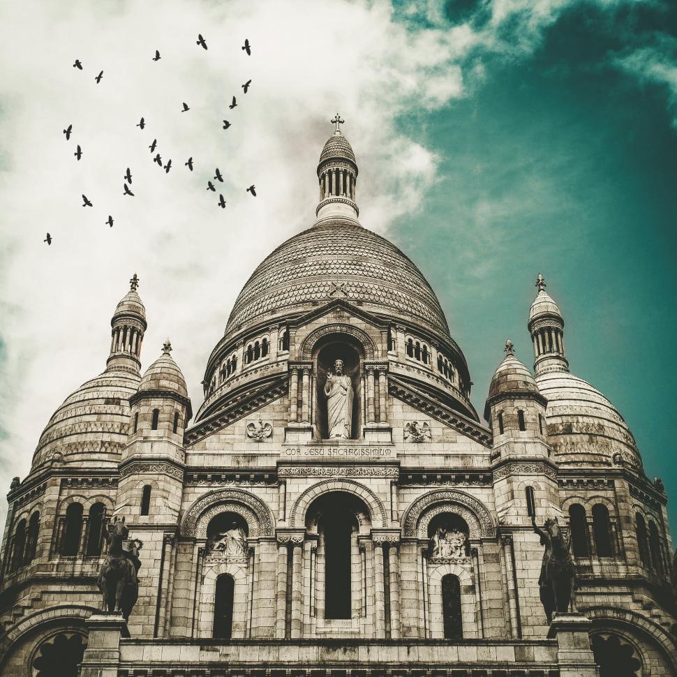 Free Image of Birds Flying Over Large Building 