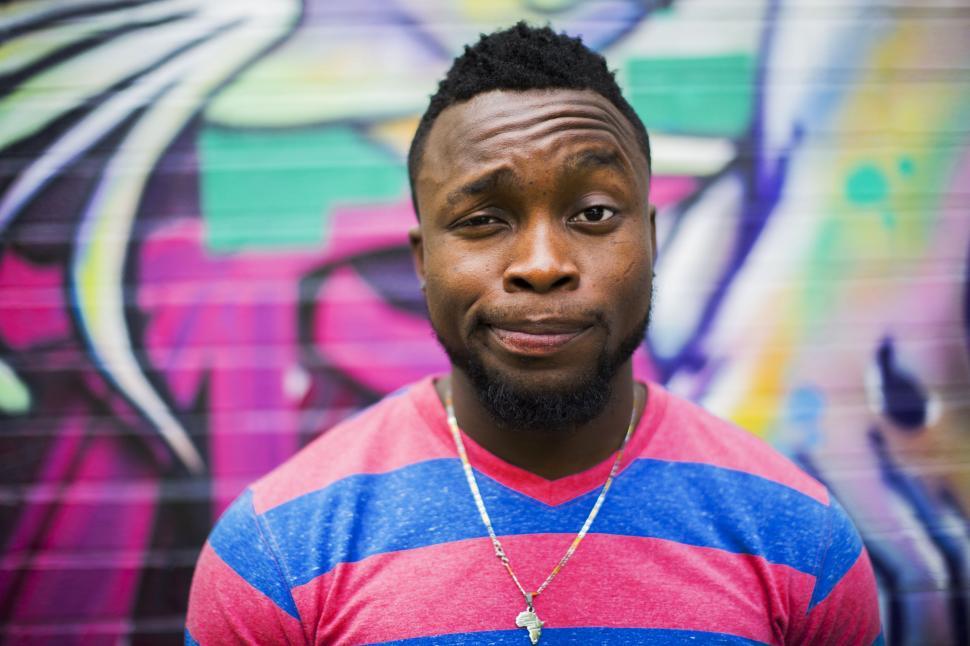 Free Image of A Man Standing in Front of a Colorful Wall 