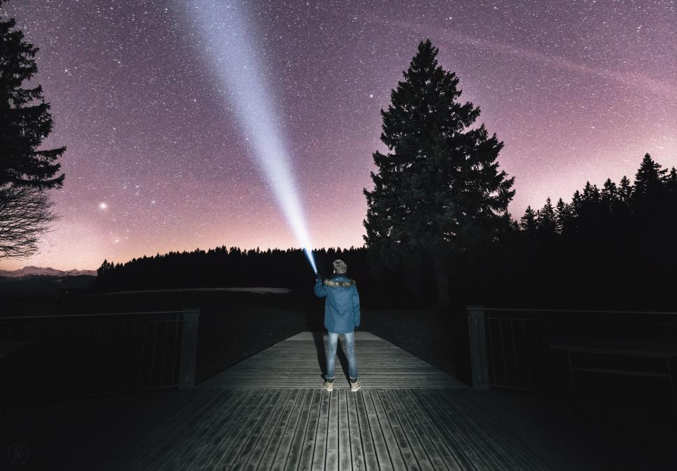Free Image of Person Standing on Wooden Walkway Under Purple Sky 