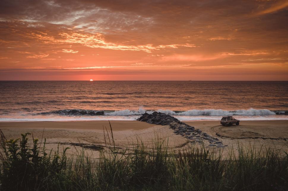 Free Image of Car Parked on Beach at Sunset 