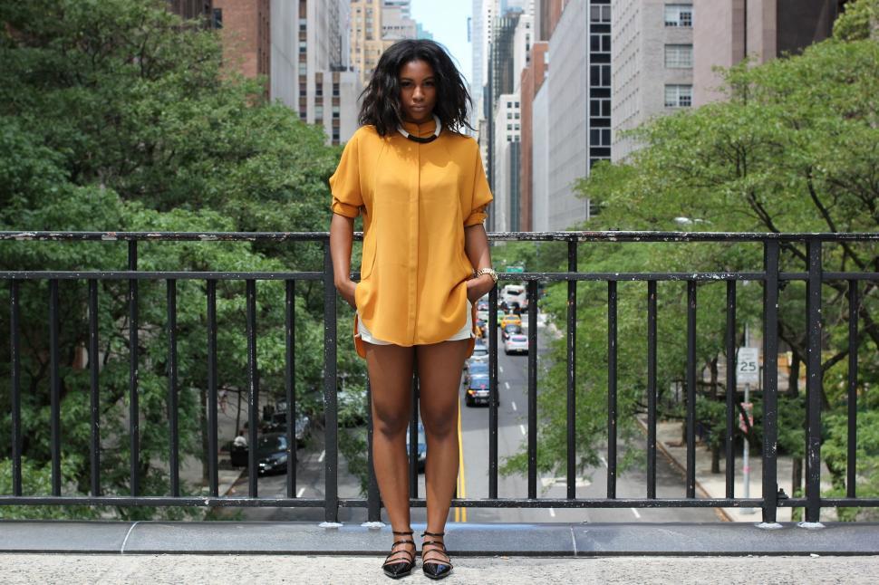 Free Image of Woman Standing on Sidewalk in City 