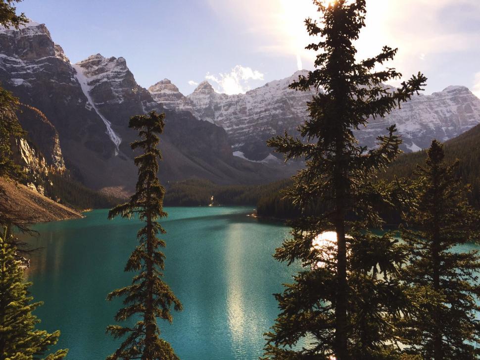 Free Image of Lake Surrounded by Trees With Mountains in Background 