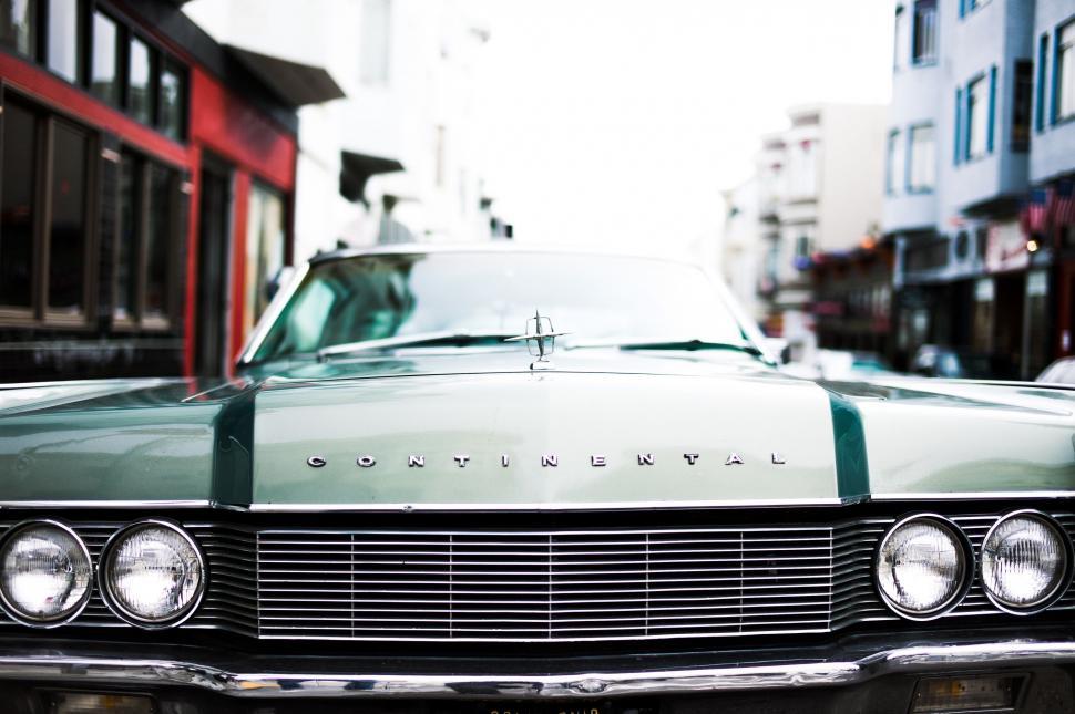 Free Image of Green and White Car Parked in Front of Building 