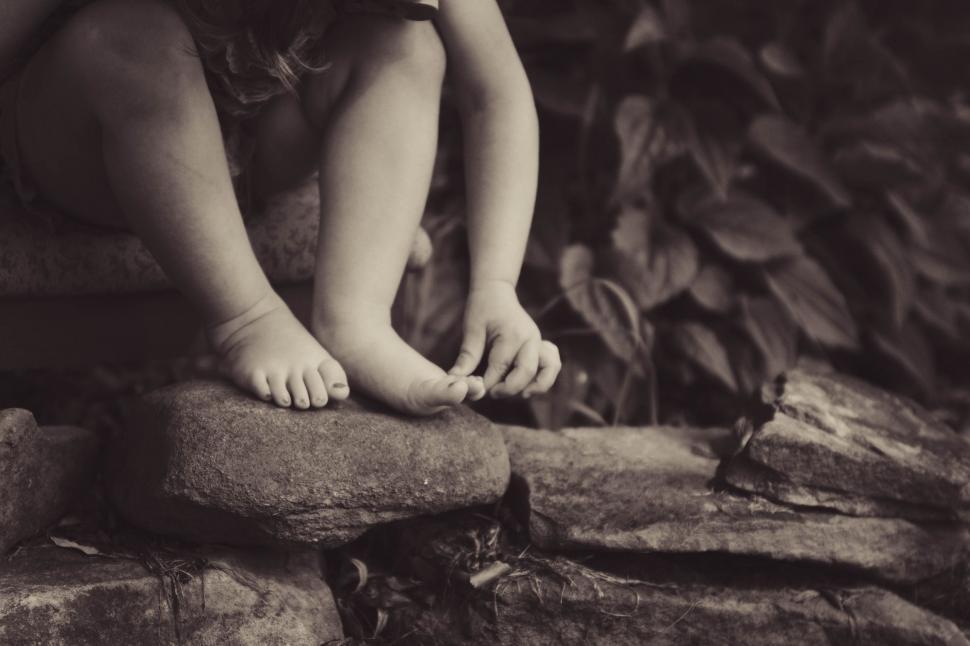Free Image of Young Girl Sitting on a Rock 