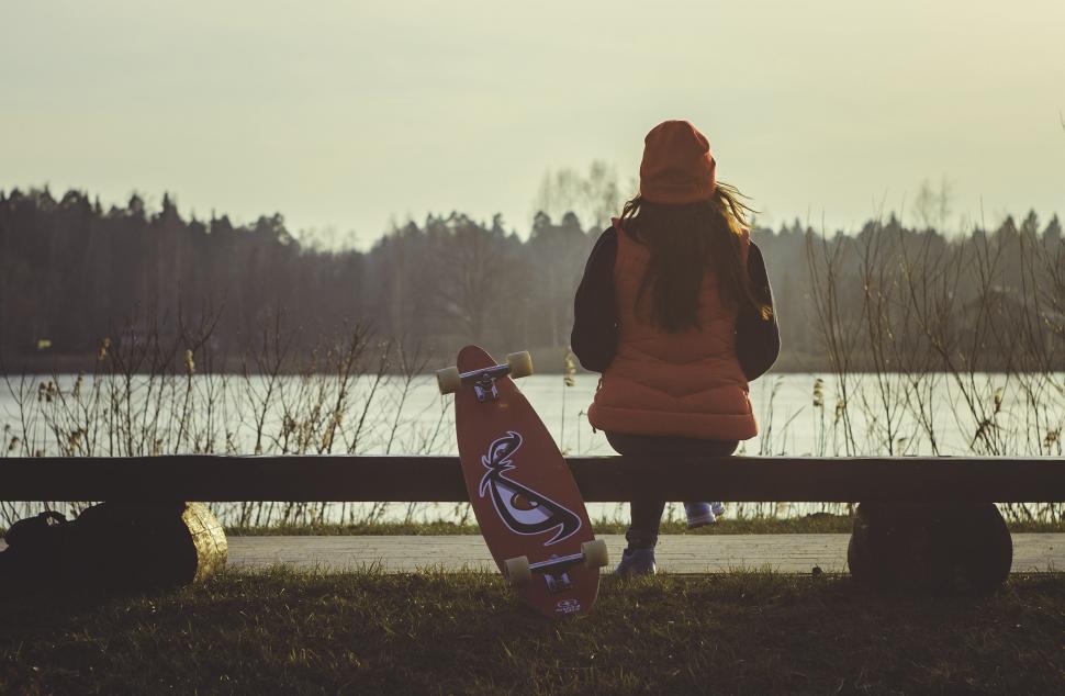 Free Image of Person Sitting on Bench With Skateboard 