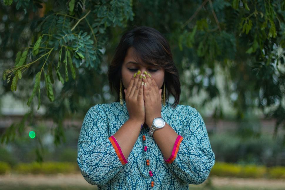 Free Image of Woman Covering Face With Hands 