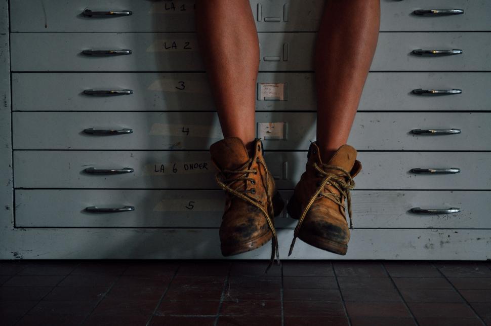 Free Image of Person Standing on Top of a Filing Cabinet 