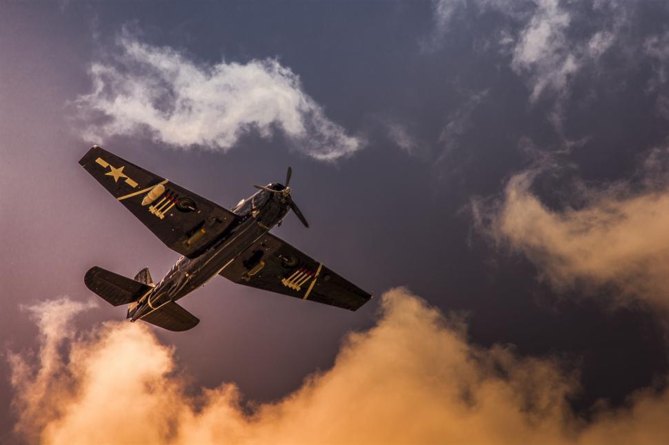 Free Image of Small Plane Flying Through Cloudy Sky 