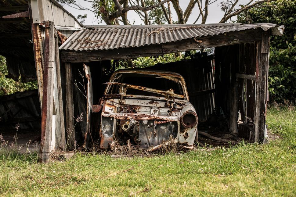 Free Image of A Rusted Out Car Abandoned in a Field 